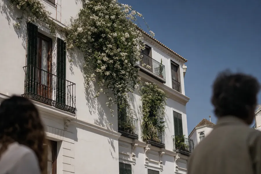 Fachada encalada de Málaga con balcones de hierro y buganvilla
