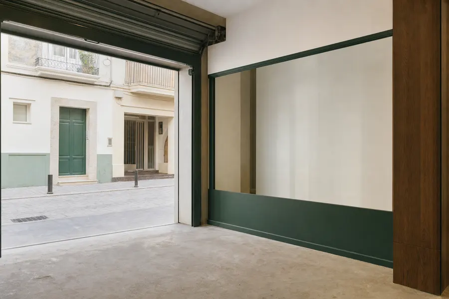Local comercial vacío a pie de calle con escaparate y persiana subida