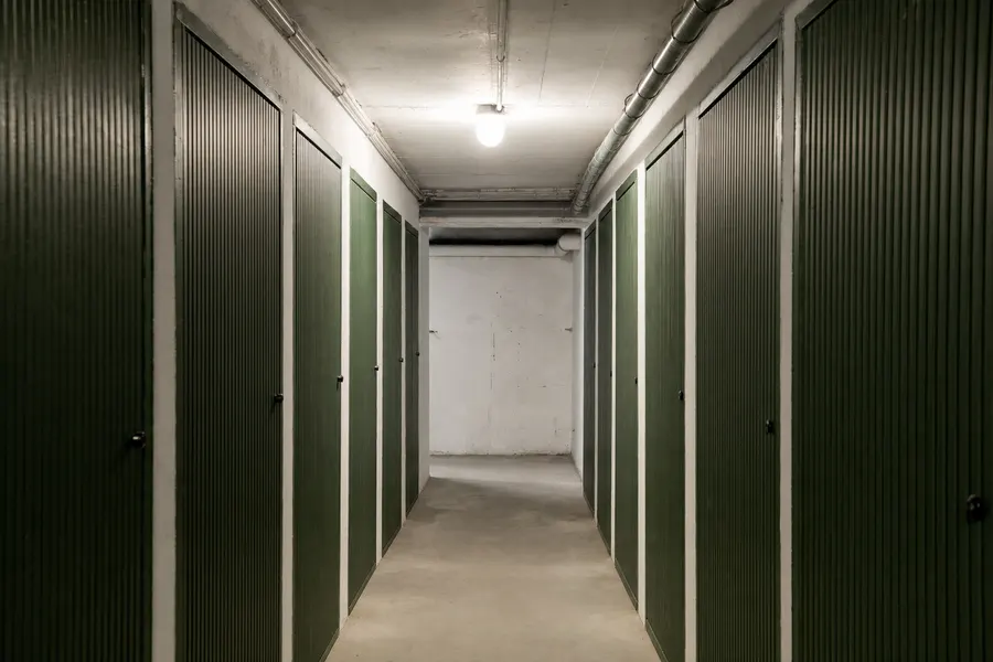 Pasillo de trasteros en un sótano, con las puertas metálicas cerradas a ambos lados