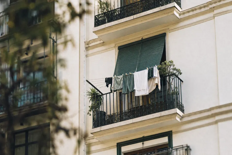 Puerta de un piso con felpudo y las llaves puestas en la cerradura